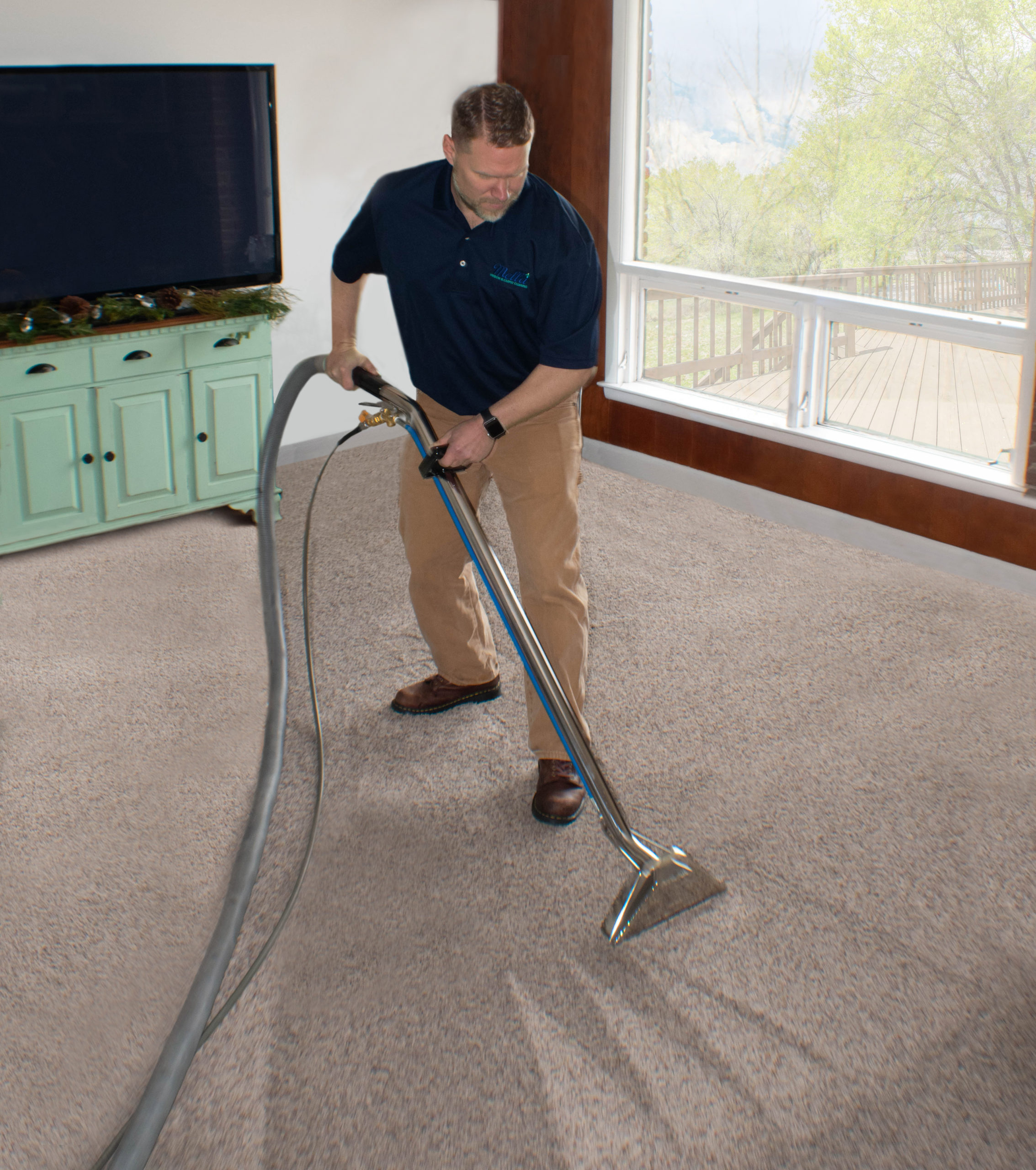 A Mella service professional thoroughly cleans a carpet.